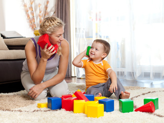 A mother and her son playing with toys and looking at each other