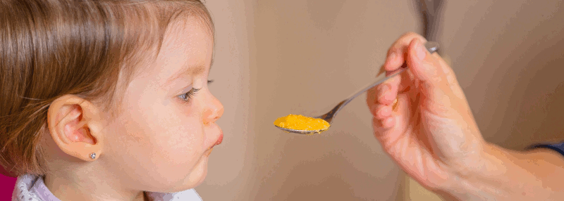 A baby being offered a spoonful of food